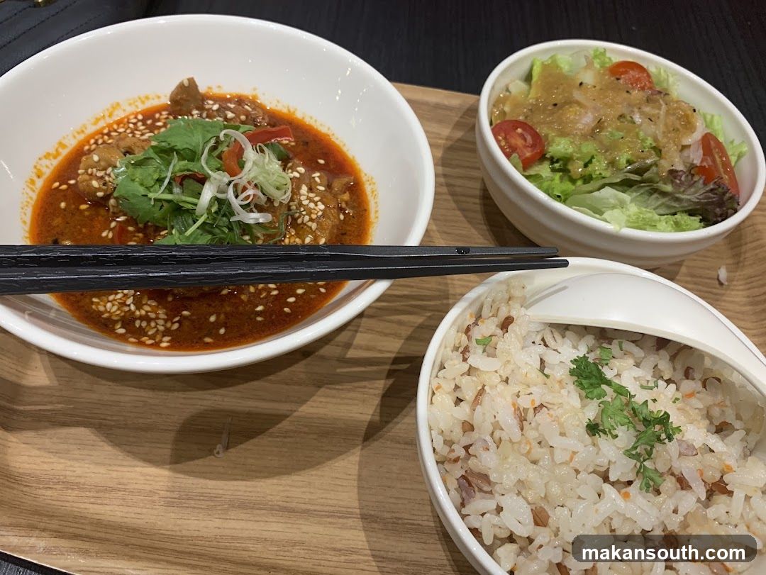 Meal with spicy soup, salad and rice