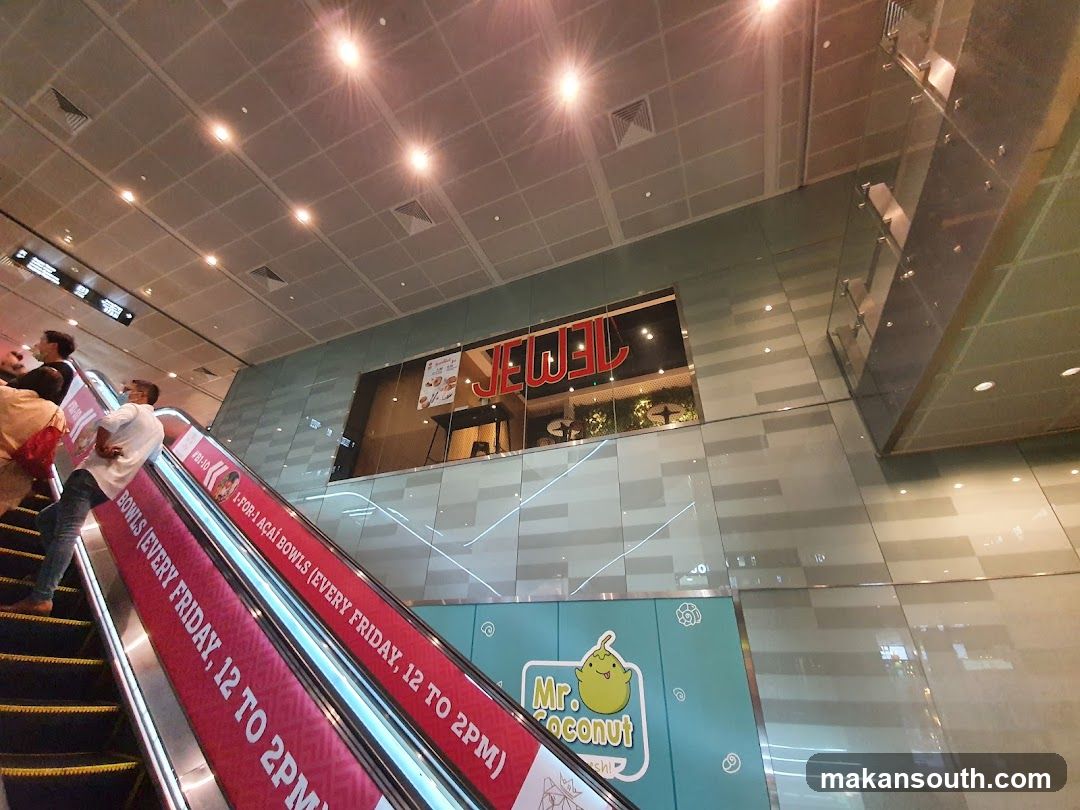 Shopping Mall Interior with Escalator and Storefronts