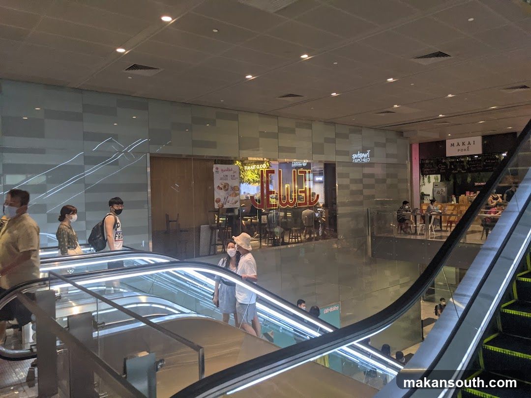 Shopping Mall Interior with Escalator and Storefronts