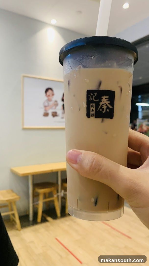 A cup of milk tea held in a hand