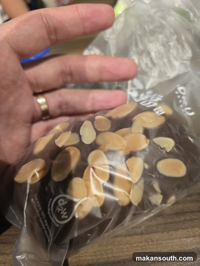 Hand holding packaged almond chocolate bar