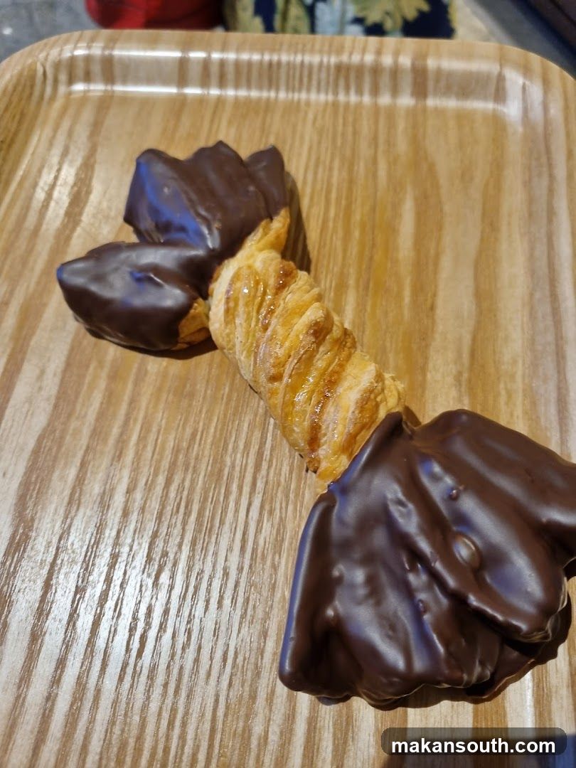 Chocolate-dipped pastry on wooden tray