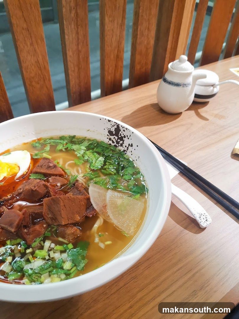Bowl of Beef Broth Noodles with Egg and Greens