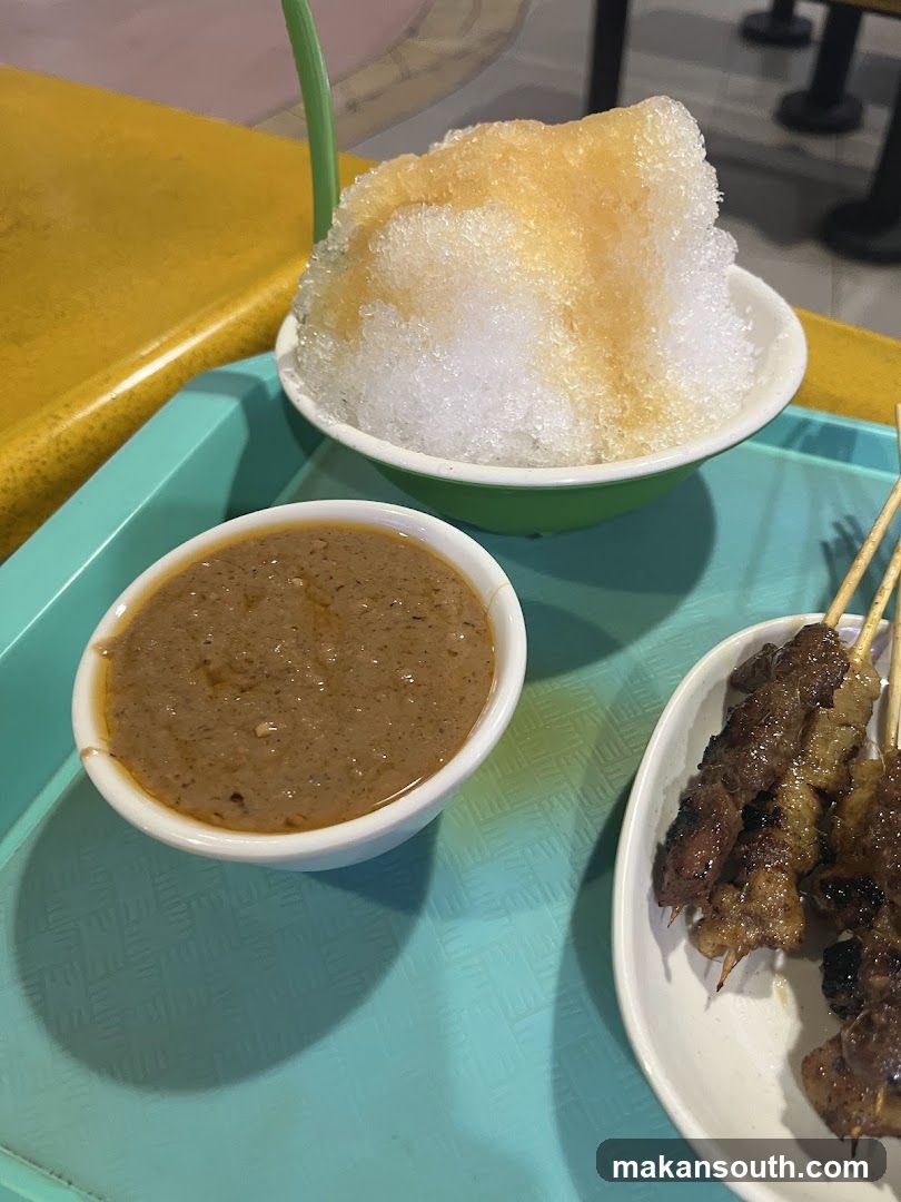 Bowl of shaved ice with sauce and skewers