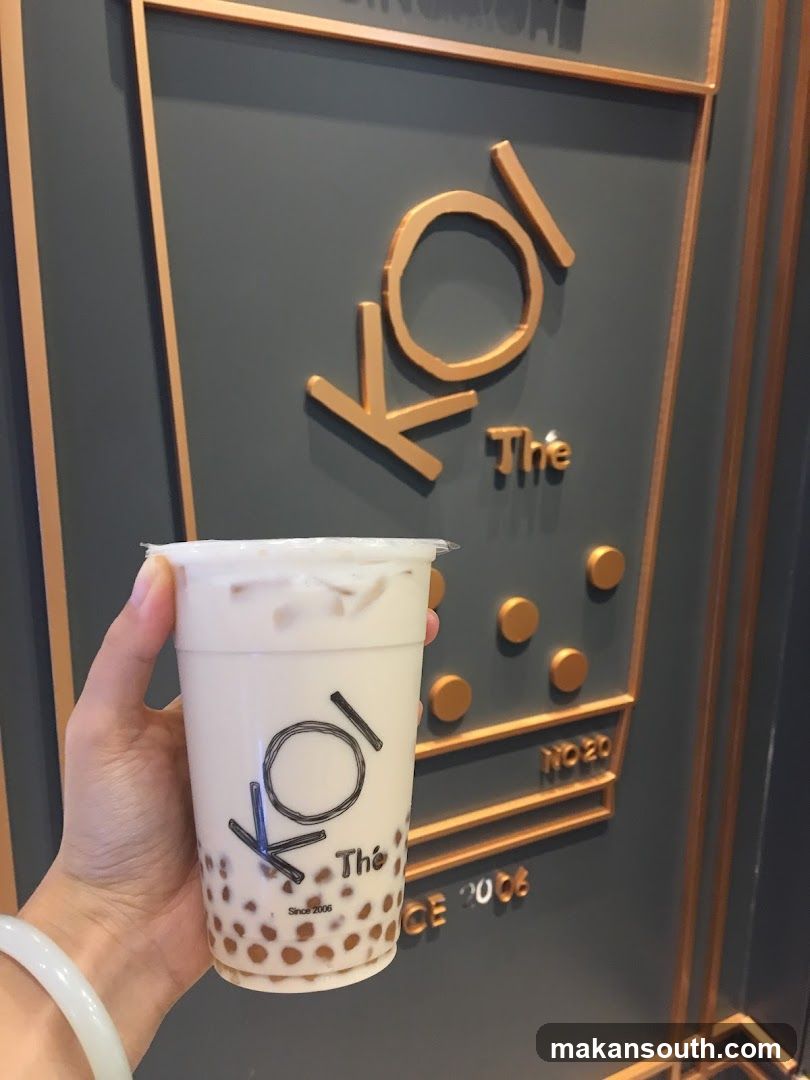 Boba Milk Tea Cup in Front of Koi The Signage