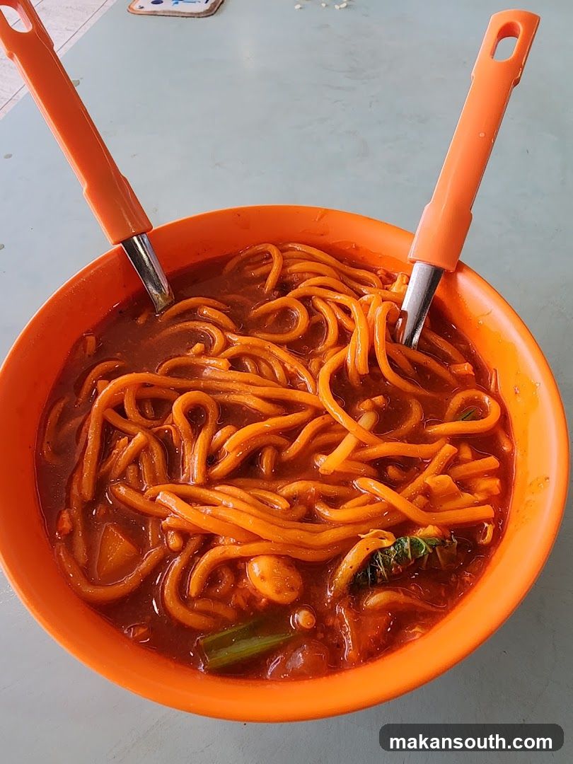 Bowl of Noodles with Orange Utensils