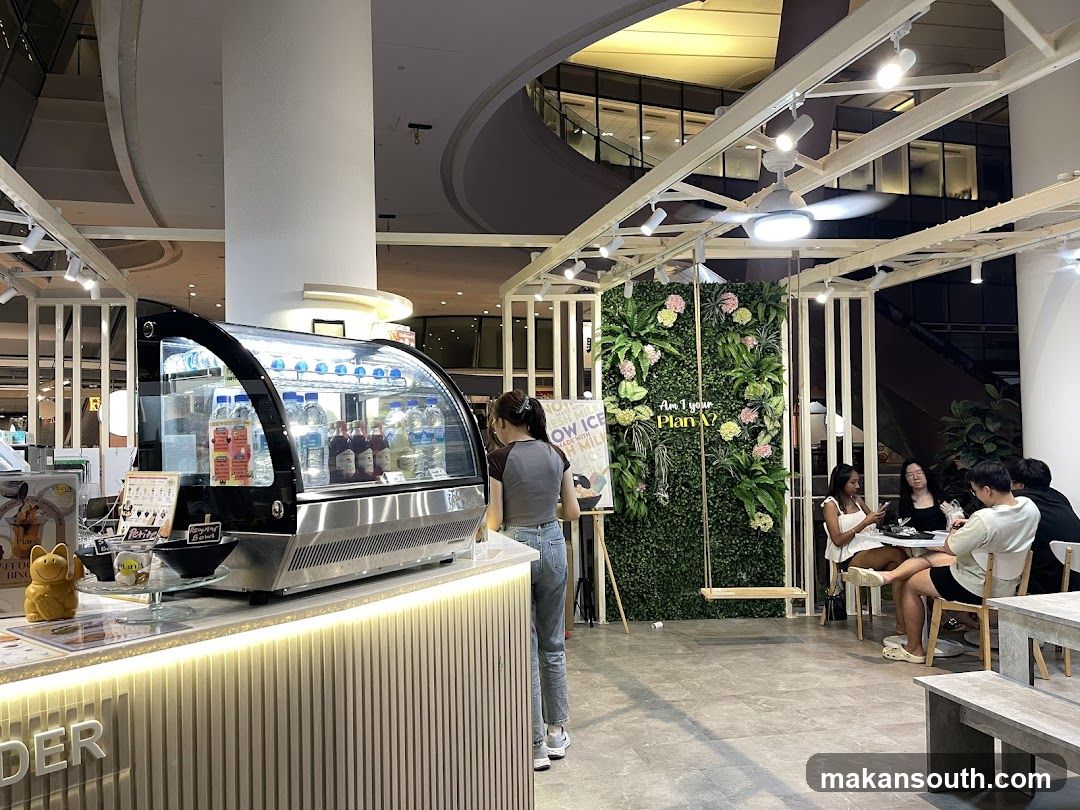 Indoor Cafe Interior with Beverage Counter and Green Wall Display