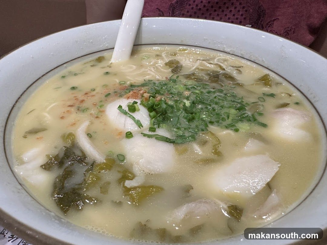 Bowl of Fish Soup with Greens and Scallions
