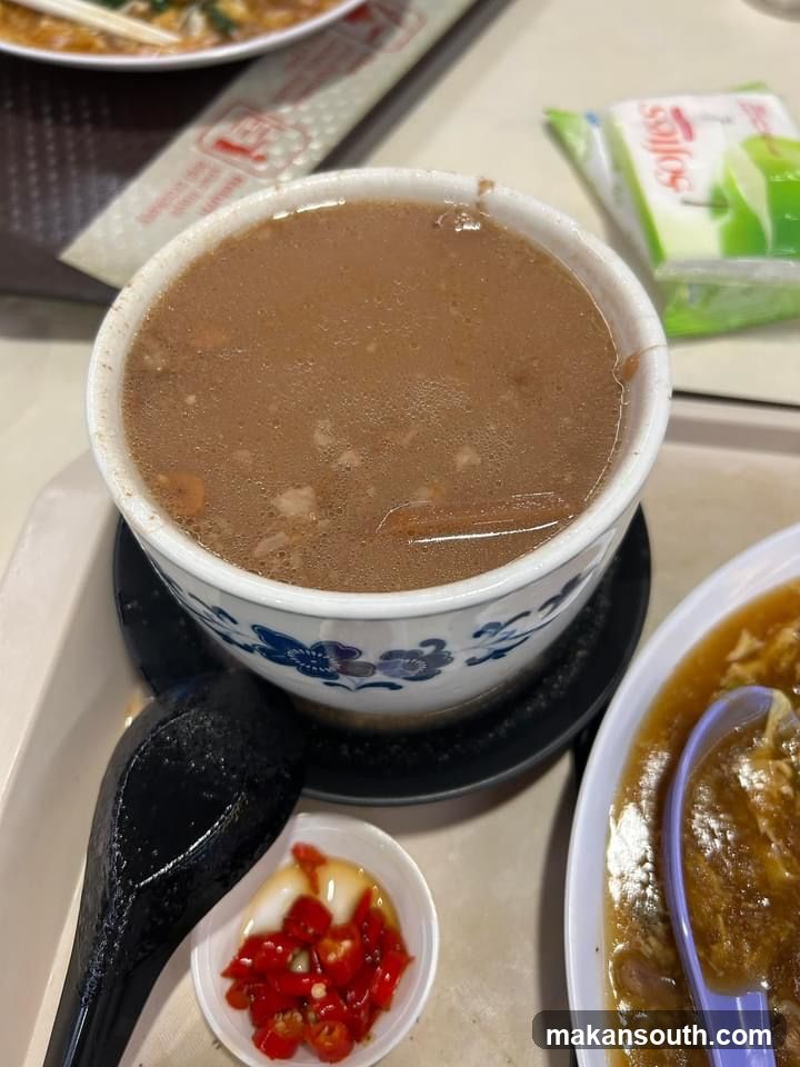 Bowl of Brown Soup with Chili Oil and Side Dishes