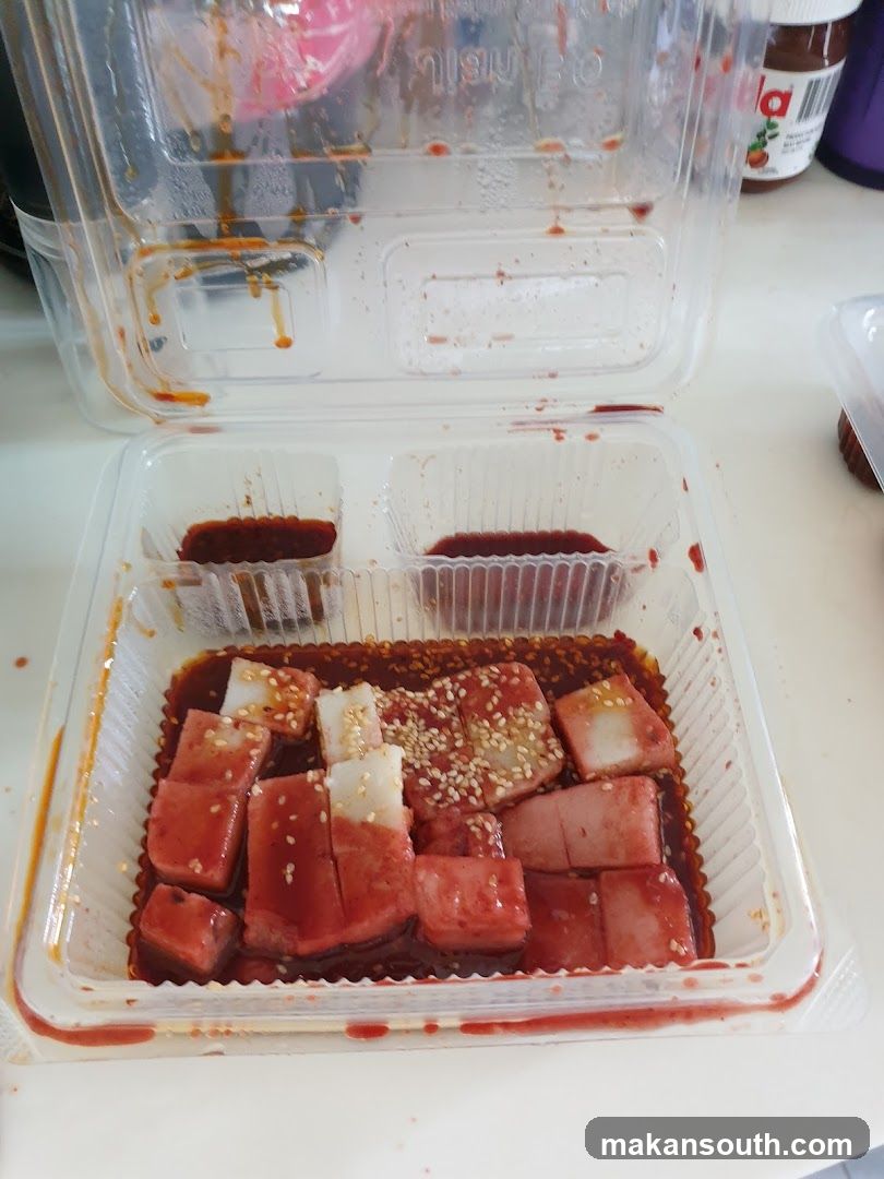 Takeout Food Container with Sauce and Cubed Meat