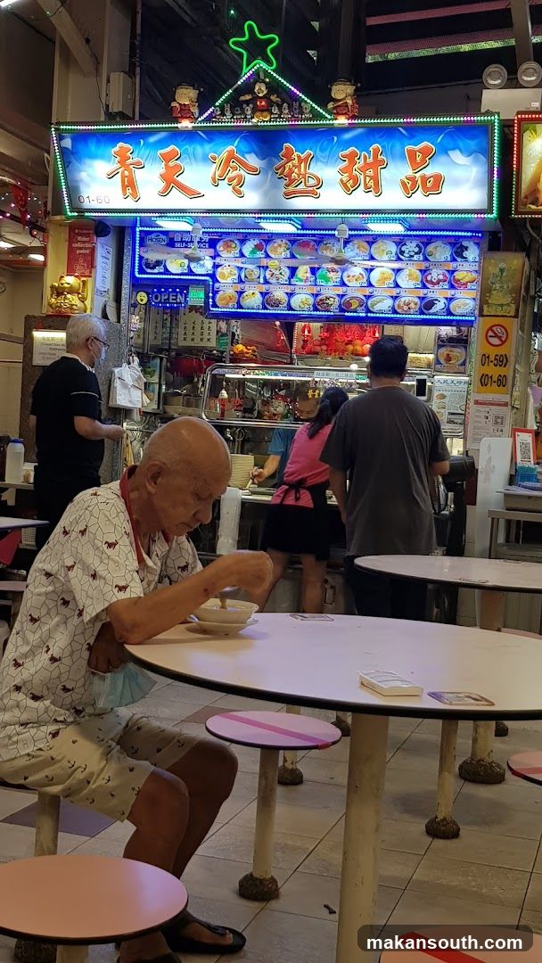 Elderly man eating at a dessert stall
