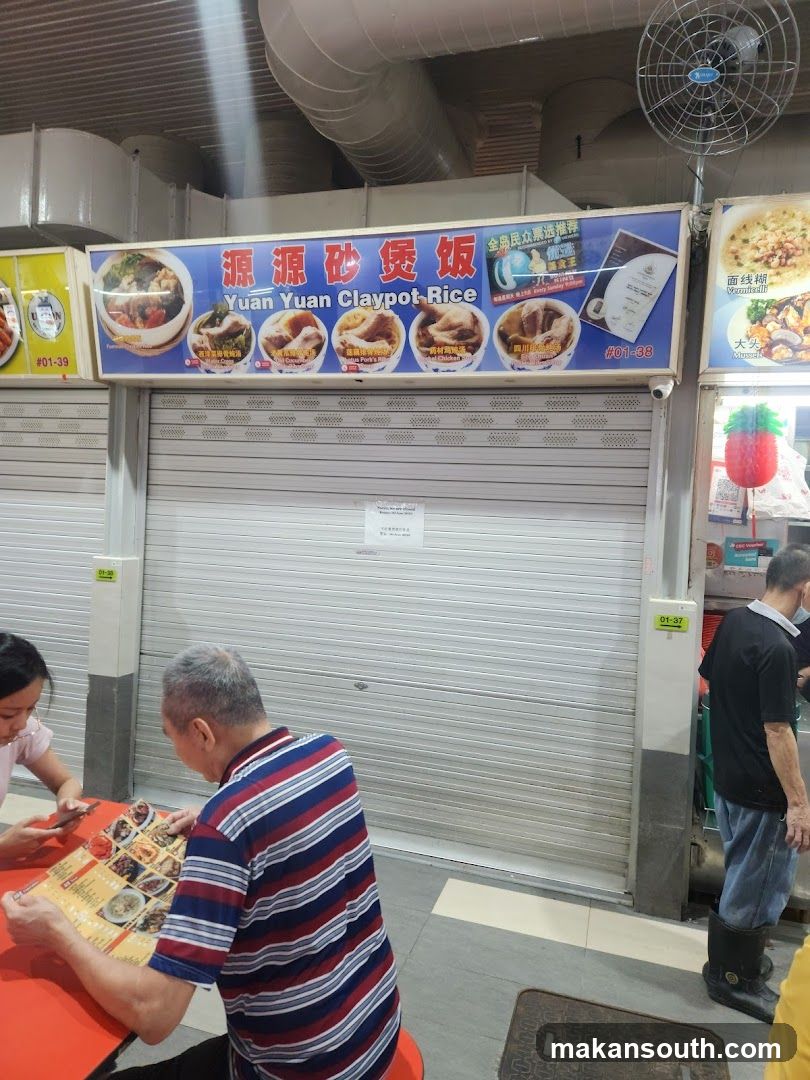 Food stall interior with customers and closed shutter