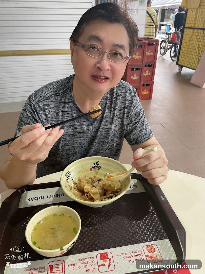Man eating noodles at a food stall