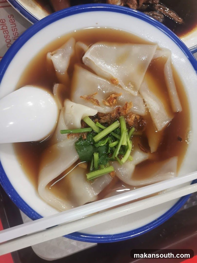 Bowl of Wonton Noodles with Broth and Garnish