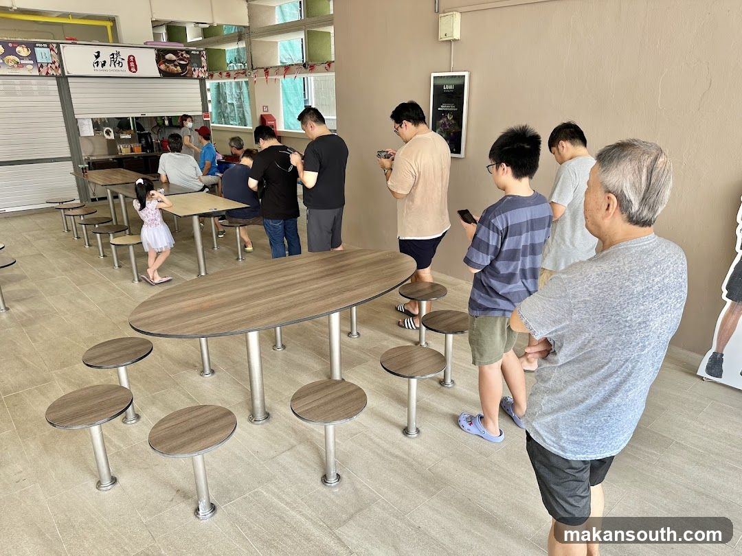 People waiting in line at a food stall