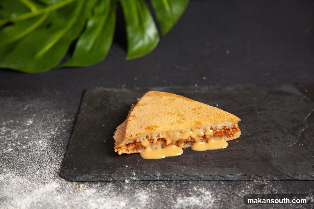 A slice of sweet crepe with peanut butter sauce
