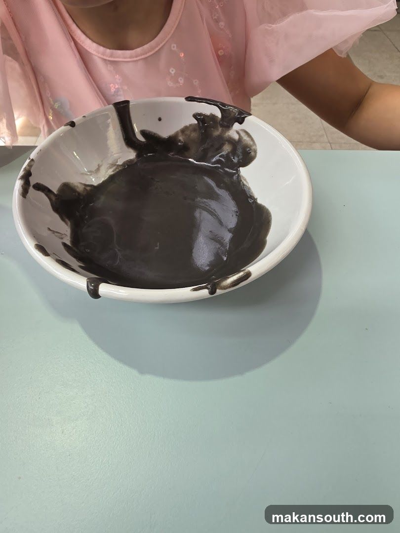 Child with Black Substance in Bowl
