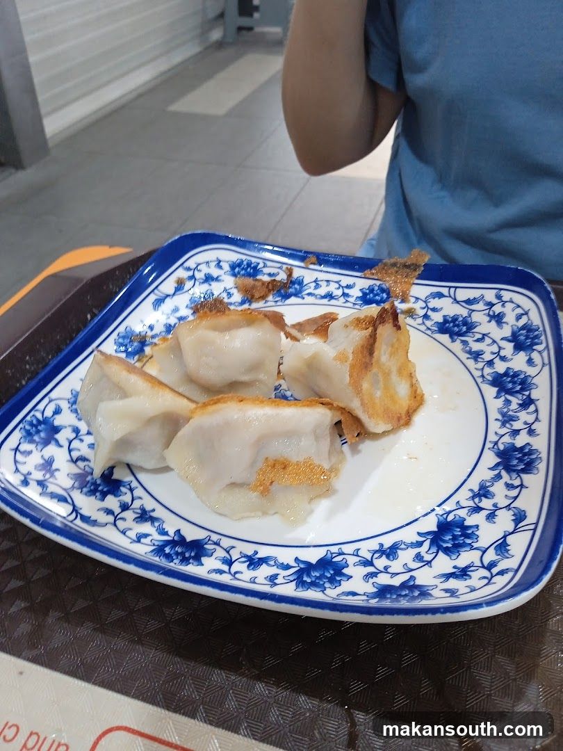 Pan-fried dumplings on a decorative plate