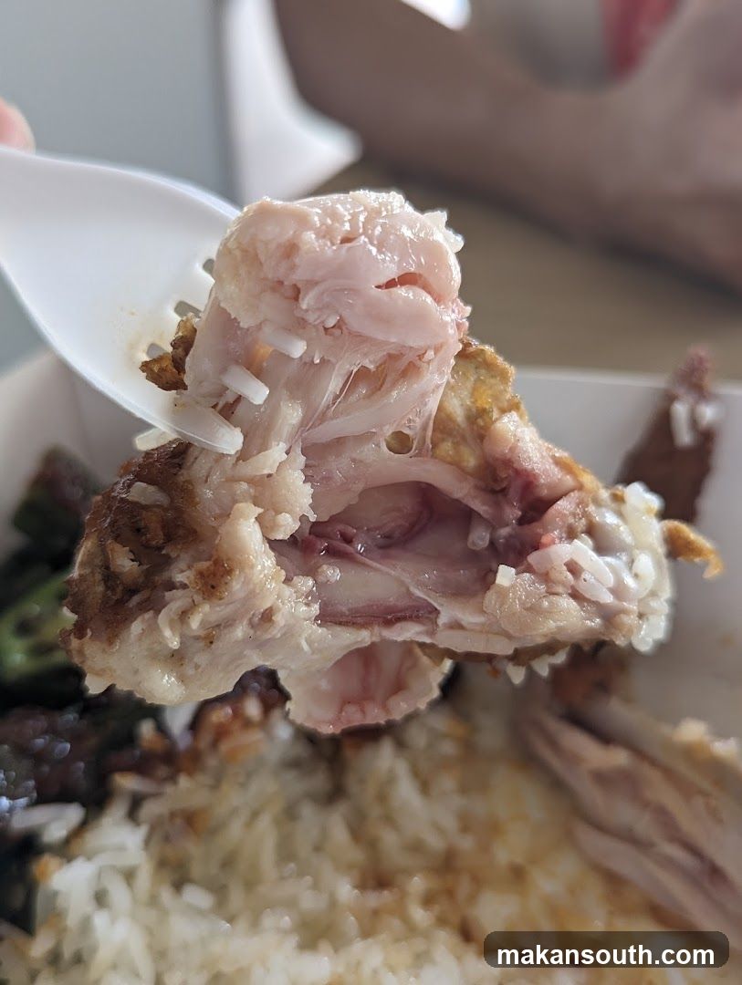 Close-up of a fork lifting a piece of cooked chicken and rice