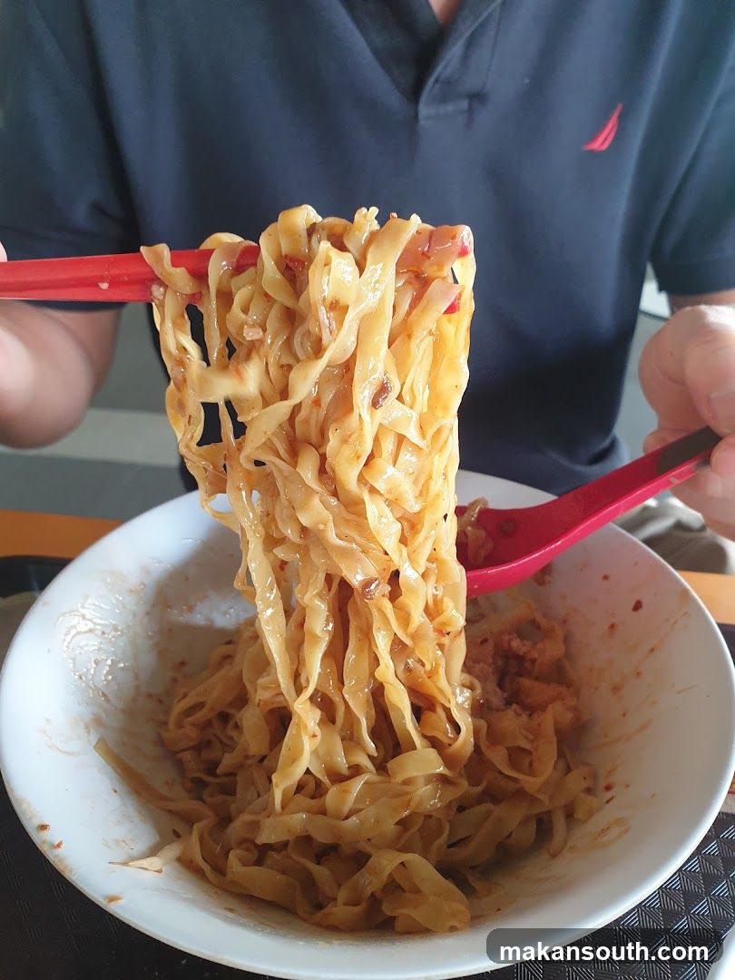 Noodles being lifted with chopsticks