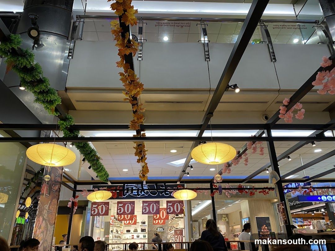 Indoor mall scene with decorative foliage and lighting