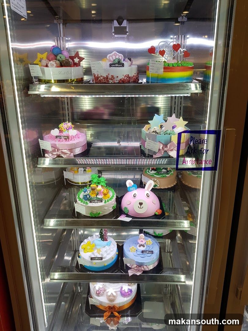 Assortment of Decorated Cakes in a Refrigerator Display