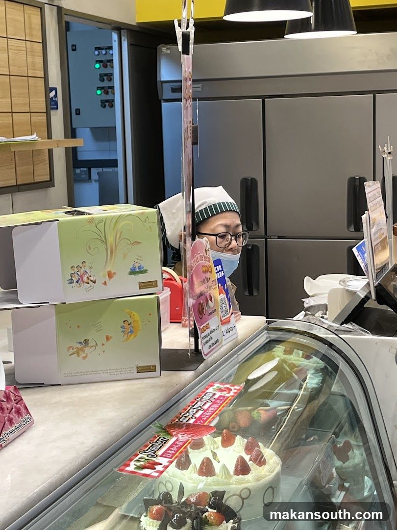 Bakery Counter with Cakes and Staff
