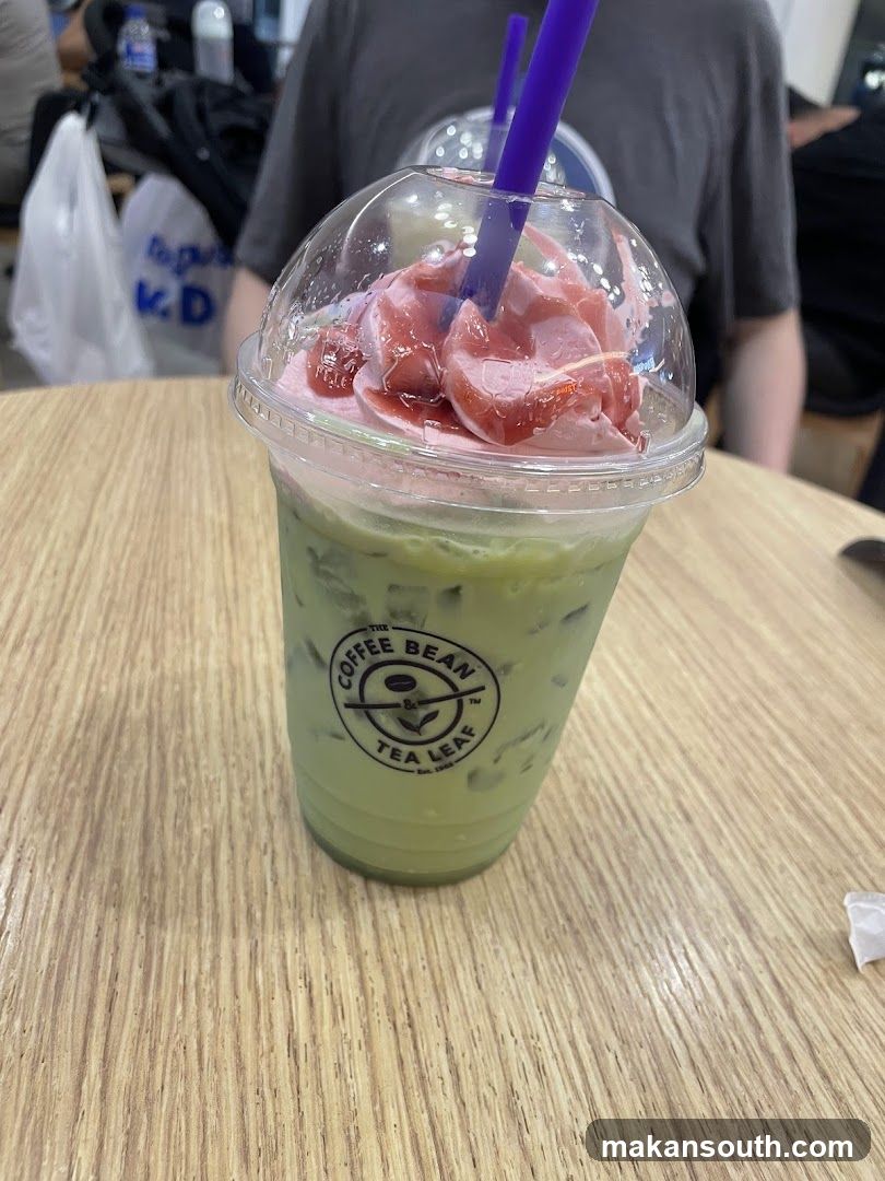 Matcha Latte with Whipped Cream and Strawberry Drizzle