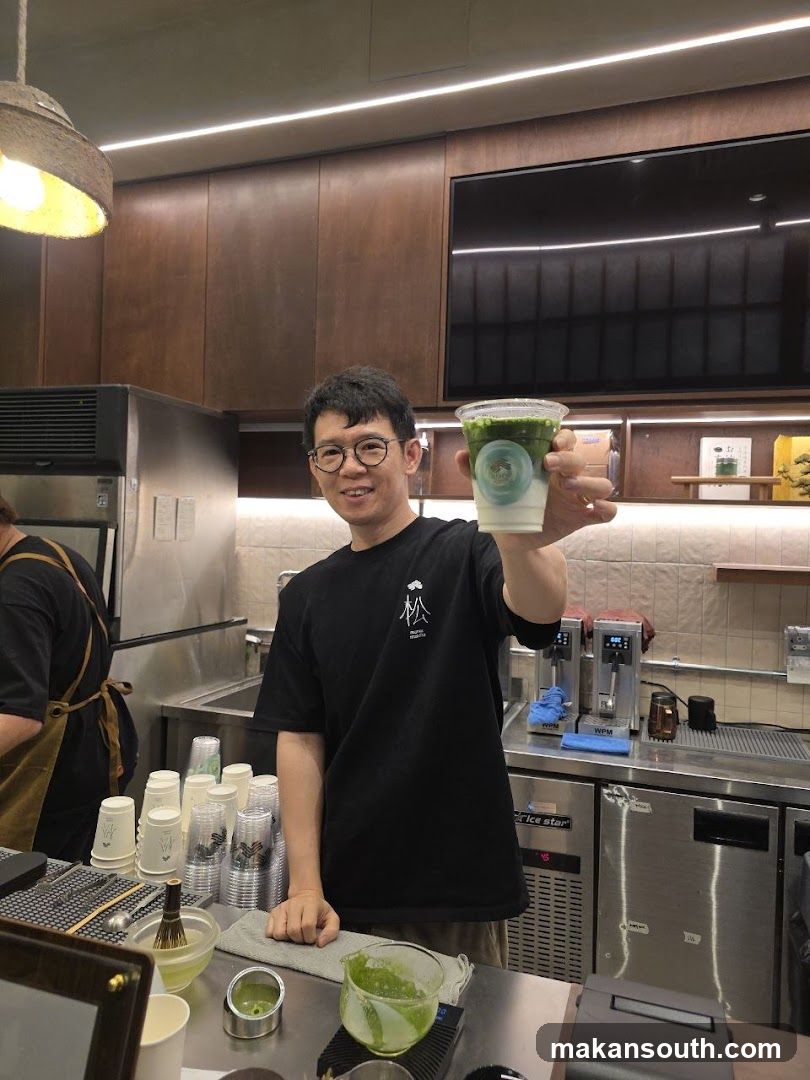 Barista holding a matcha drink