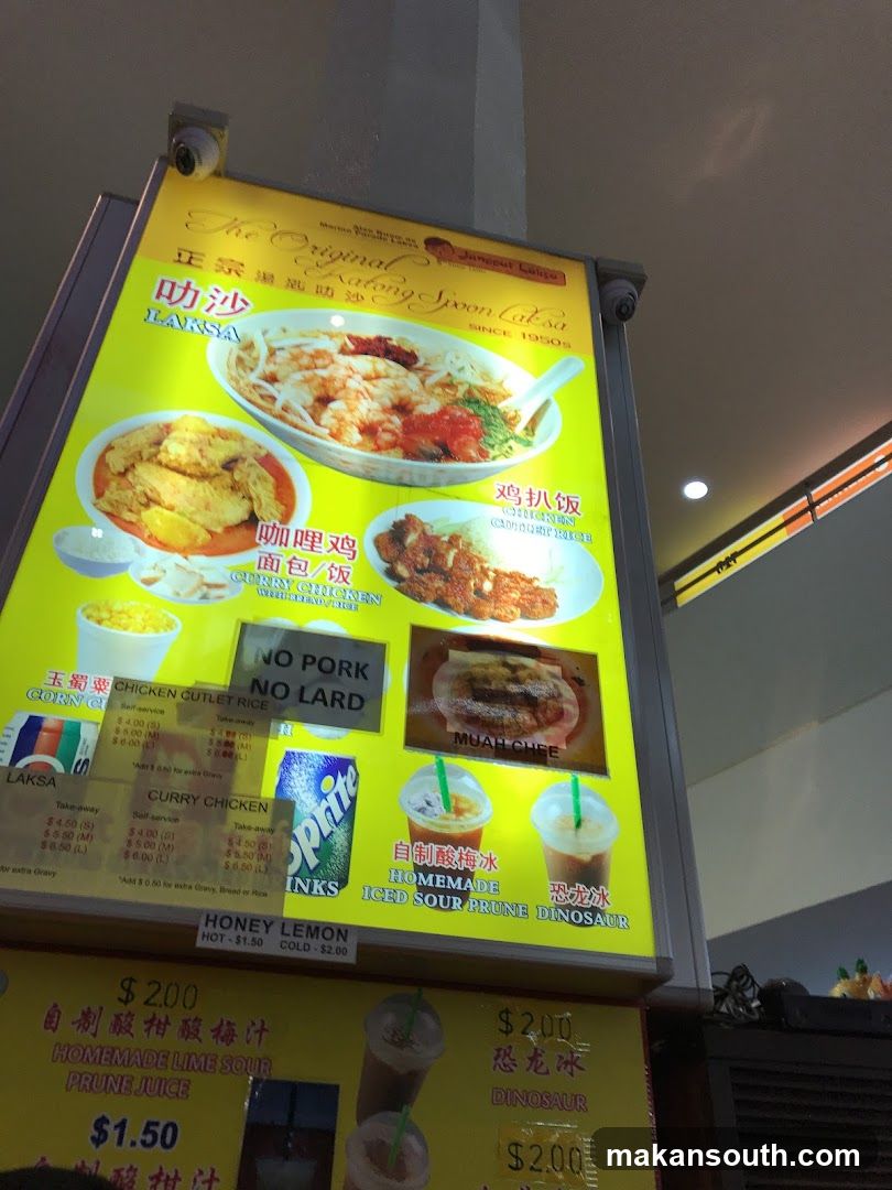 A menu board for "The Original Katong Spoon Laksa" featuring various dishes and drinks.