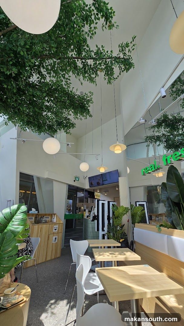 Modern cafe interior with greenery and seating