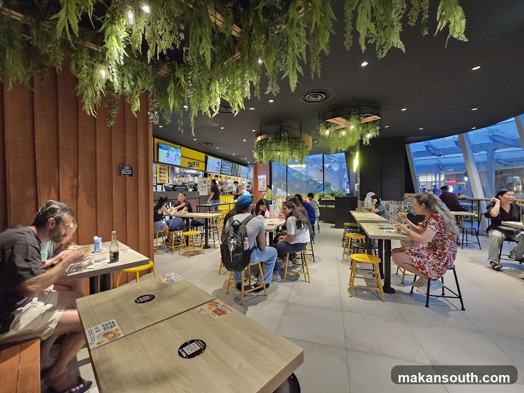 Diners in a modern restaurant with hanging plants