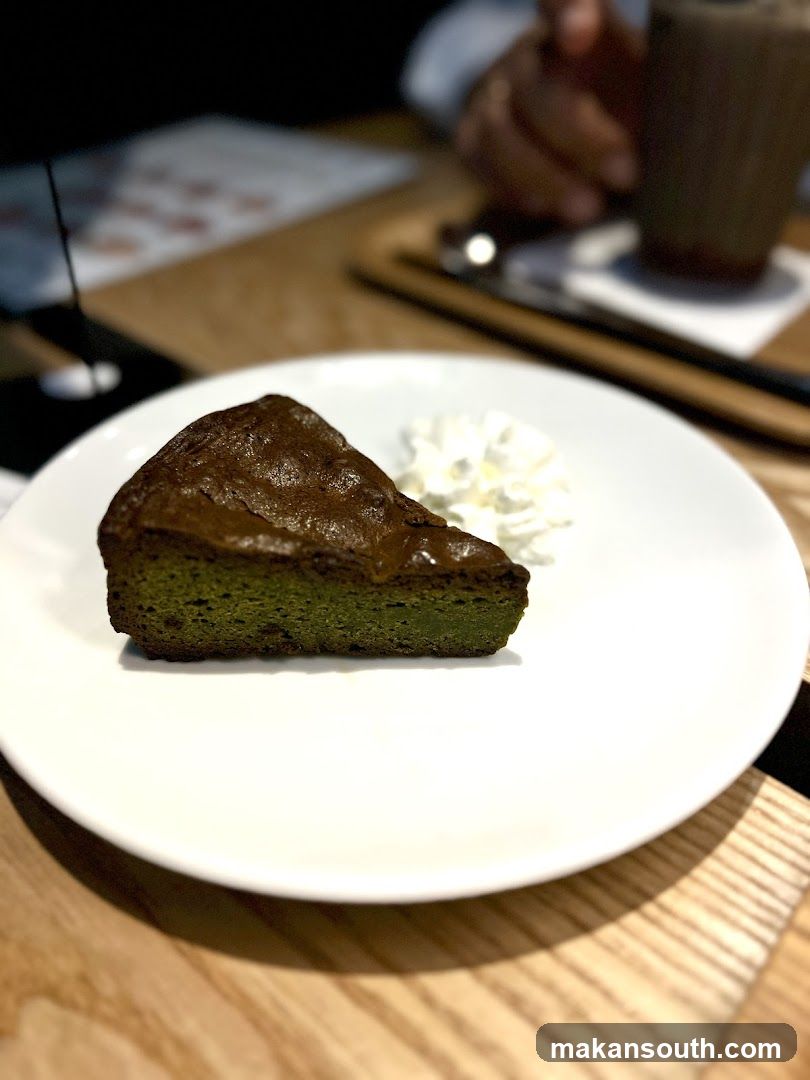 Slice of green tea cake with whipped cream