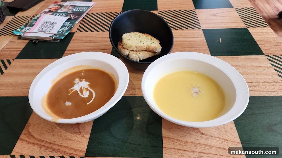 Two bowls of soup with garlic bread