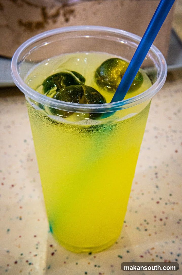 Yellow Drink with Lime Slices and Straw