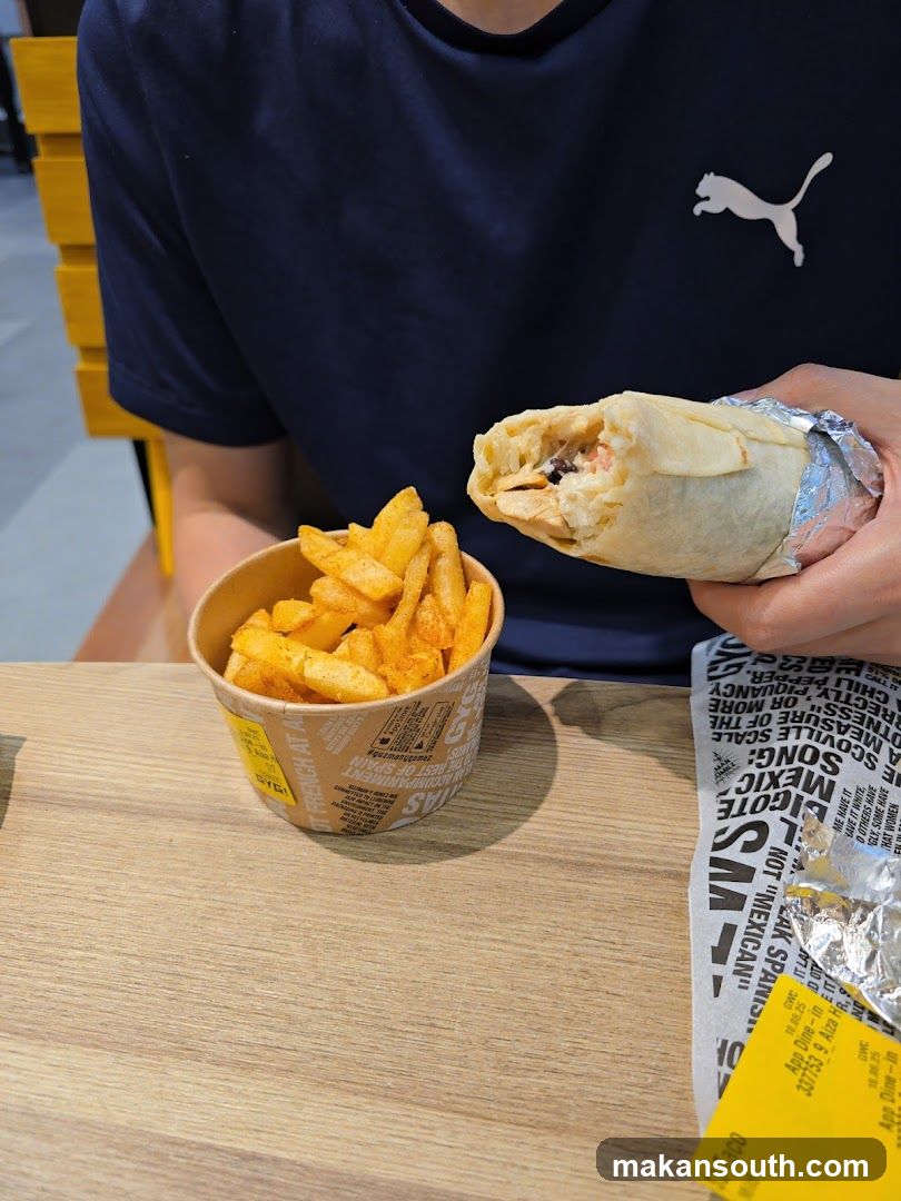 Person holding a burrito and fries