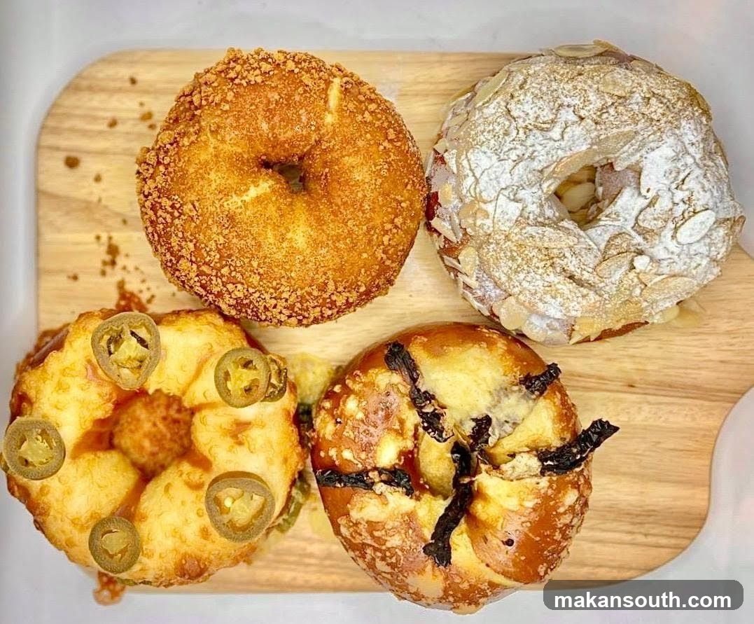 Four assorted donuts on a wooden board