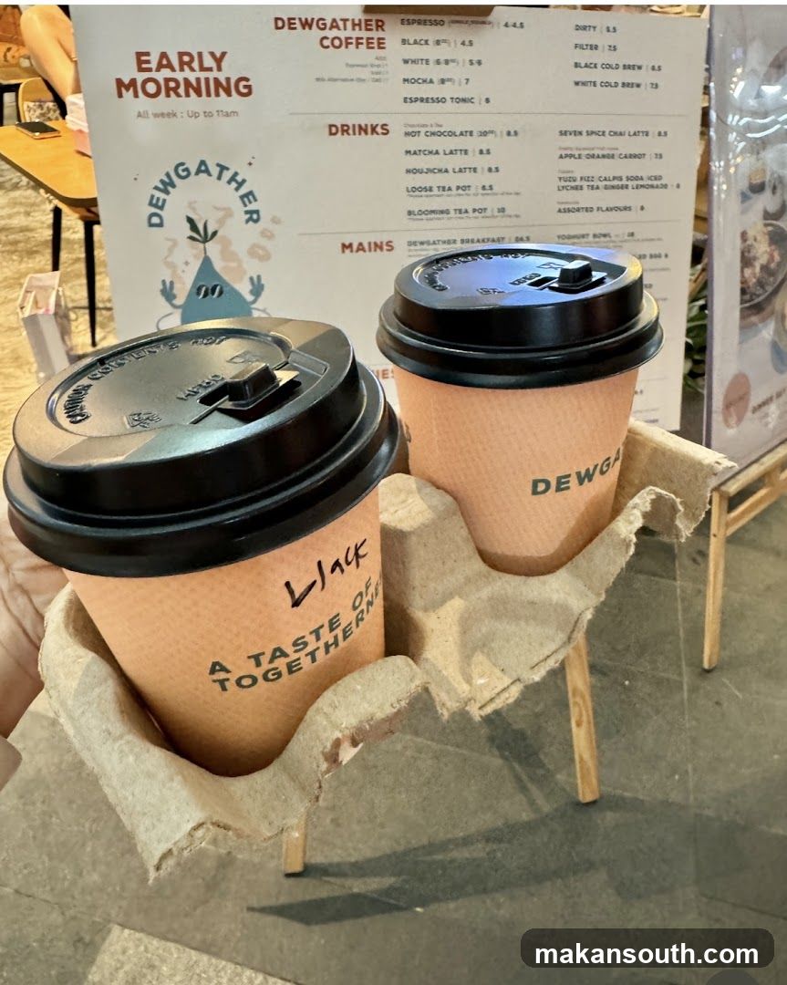 Two coffee cups with Dewgather branding