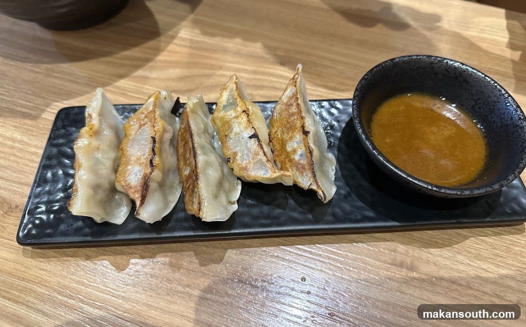 Pan-fried dumplings with dipping sauce
