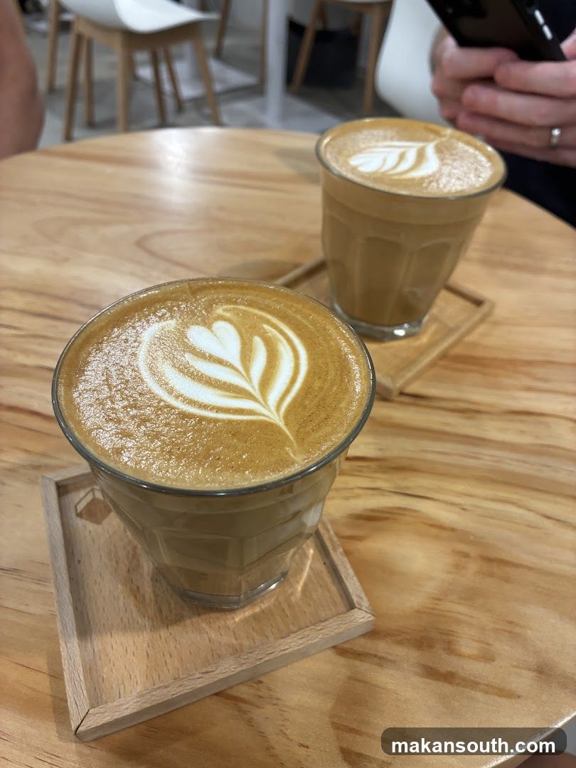 Two coffees with latte art on a wooden table