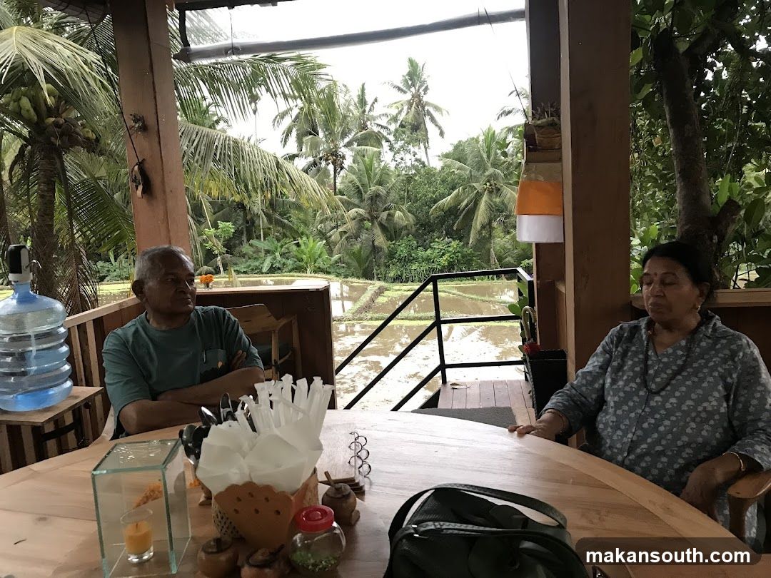 People sitting at a table overlooking rice paddies