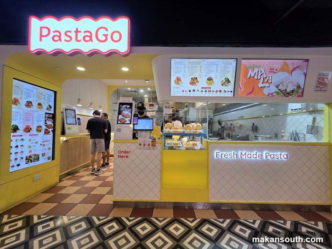 A bright yellow and white pasta shop with a prominent "PastaGo" sign. Digital menus are displayed on screens, and customers are seen ordering at self-service kiosks. The counter displays "Fresh Made Pasta" in illuminated lettering.