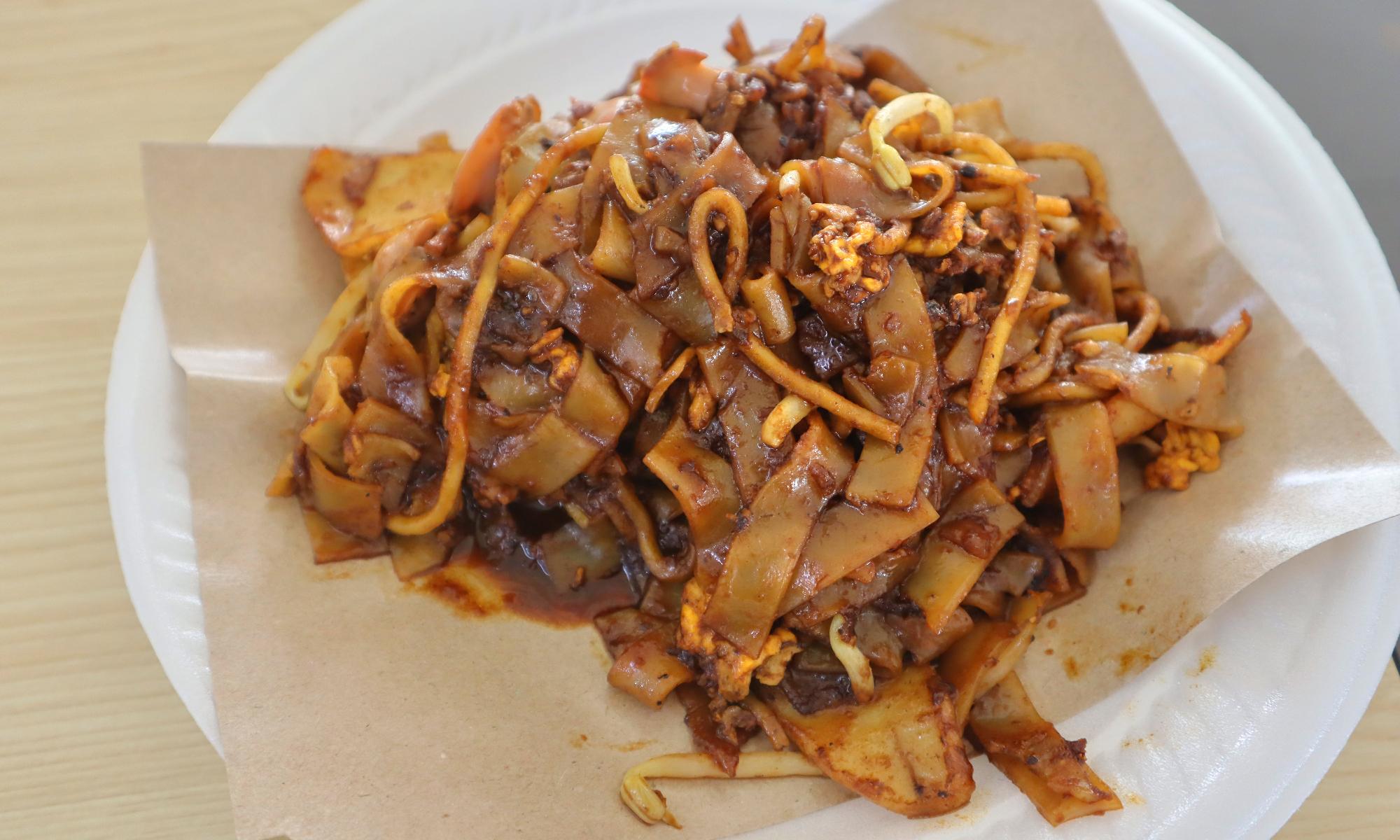 A plate of halal char kway teow from 786 Char Kway Teow at Bukit Merah View Market, with cockles, egg, bean sprouts and fishcake, listed in the MICHELIN Guide Singapore 2026