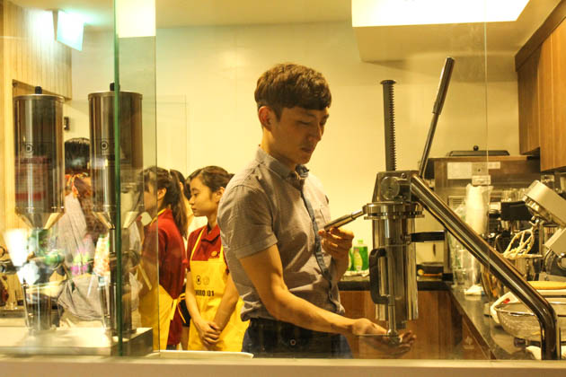 Open kitchen at a Korean-style cafe showing pastry preparation, the kind of counter layout at Visitors in Tanjong Pagar Plaza